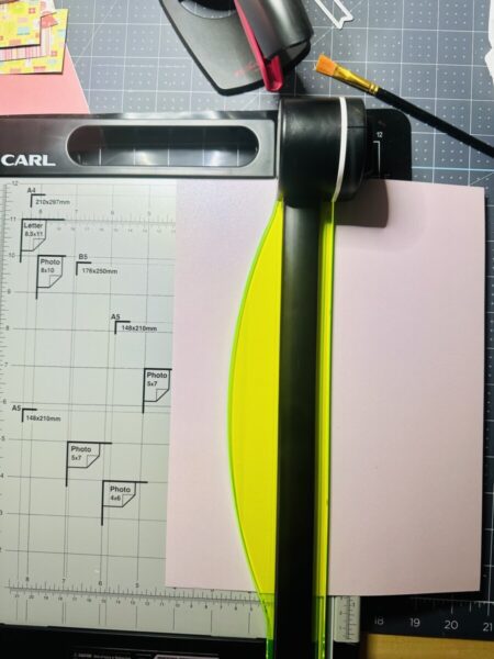 Cutting cardstock with a rotary paper trimmer.