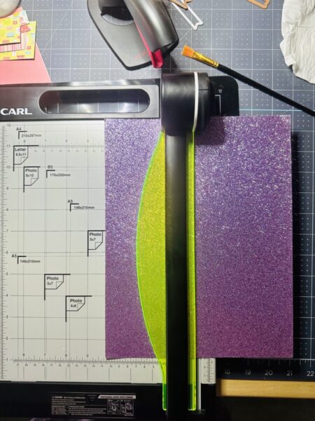 Cutting glitter cardstock with a rotary paper trimmer.